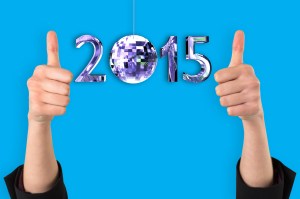 Businesswomans hands showing thumbs up against blue background with vignette